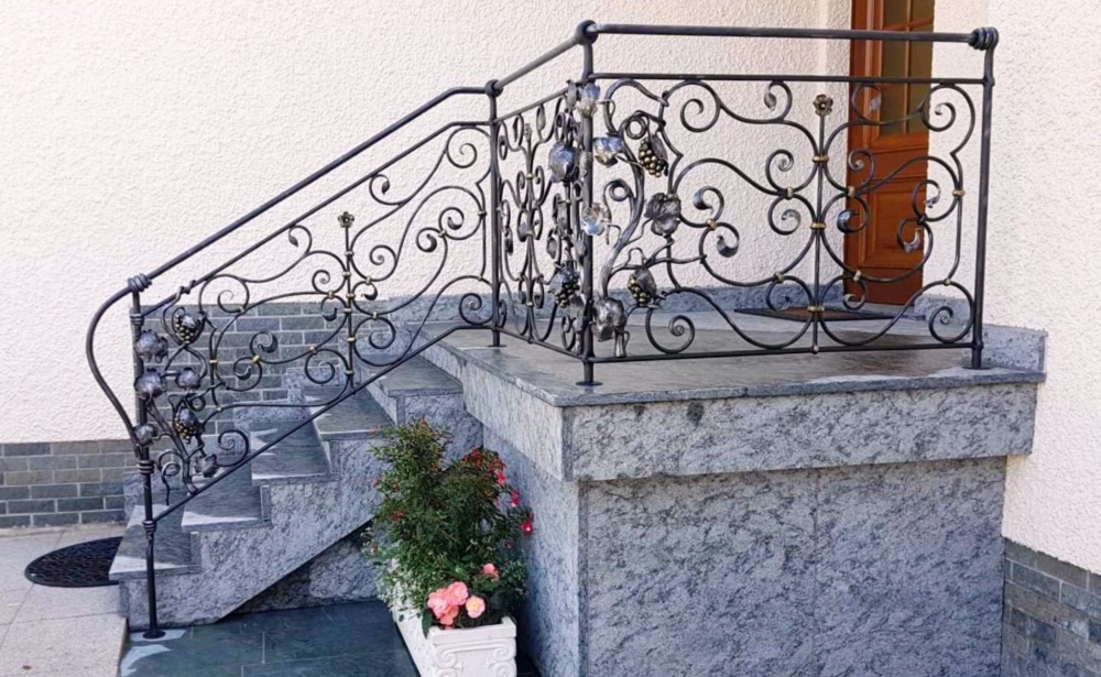 Schmiedeeisernes Geländer mit Rebstöcken und Trauben